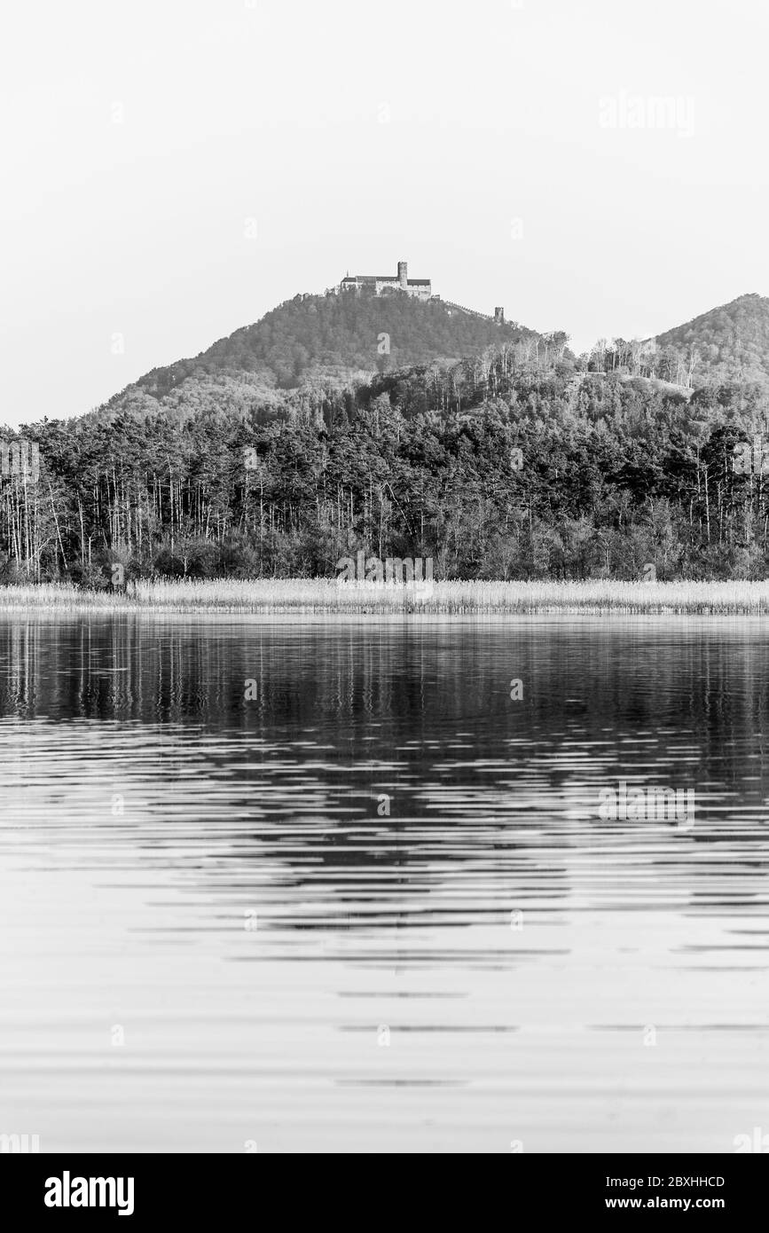 Castillo medieval Bezdez en la cima de la montaña Bezdez. Reflejado en Brehynsky Pond, República Checa. Imagen en blanco y negro. Foto de stock