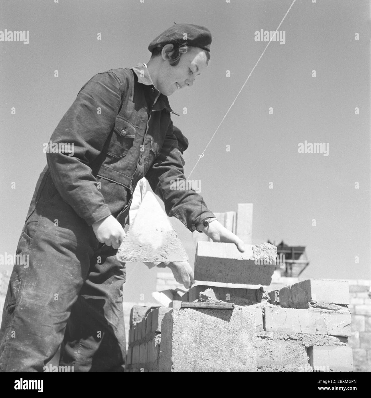 En los años 50. Las mujeres trabajadoras de la construcción están poniendo ladrillos en un edificio. SUECIA 1951. Kristoffersson ref BB93-10 Foto de stock