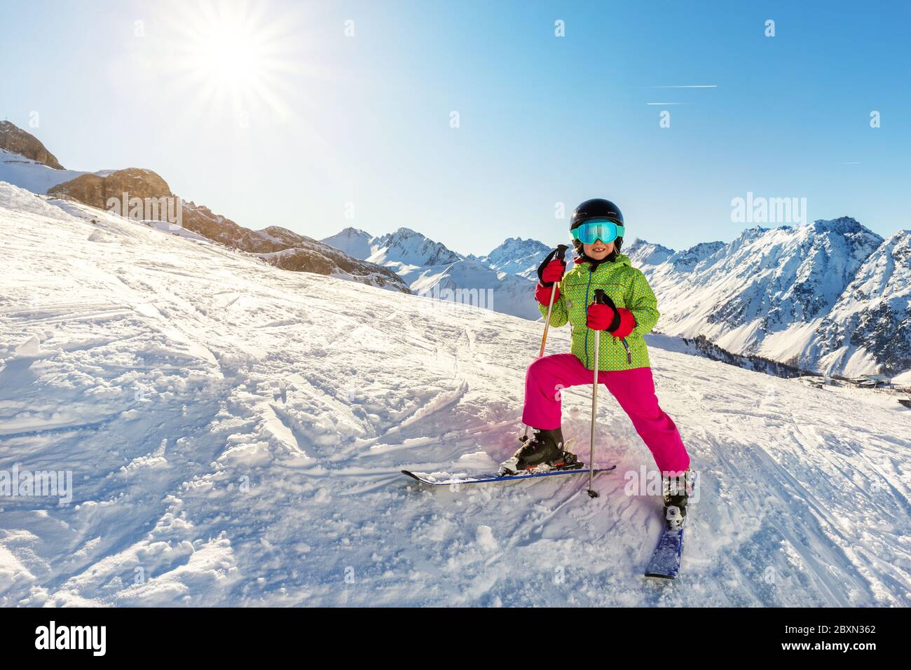 Adorable y adorable niña esquiadora en traje de esquí brillante divertirse montando esquí de montaña en el centro turístico alpino de invierno en un día soleado Fotografía de - Alamy