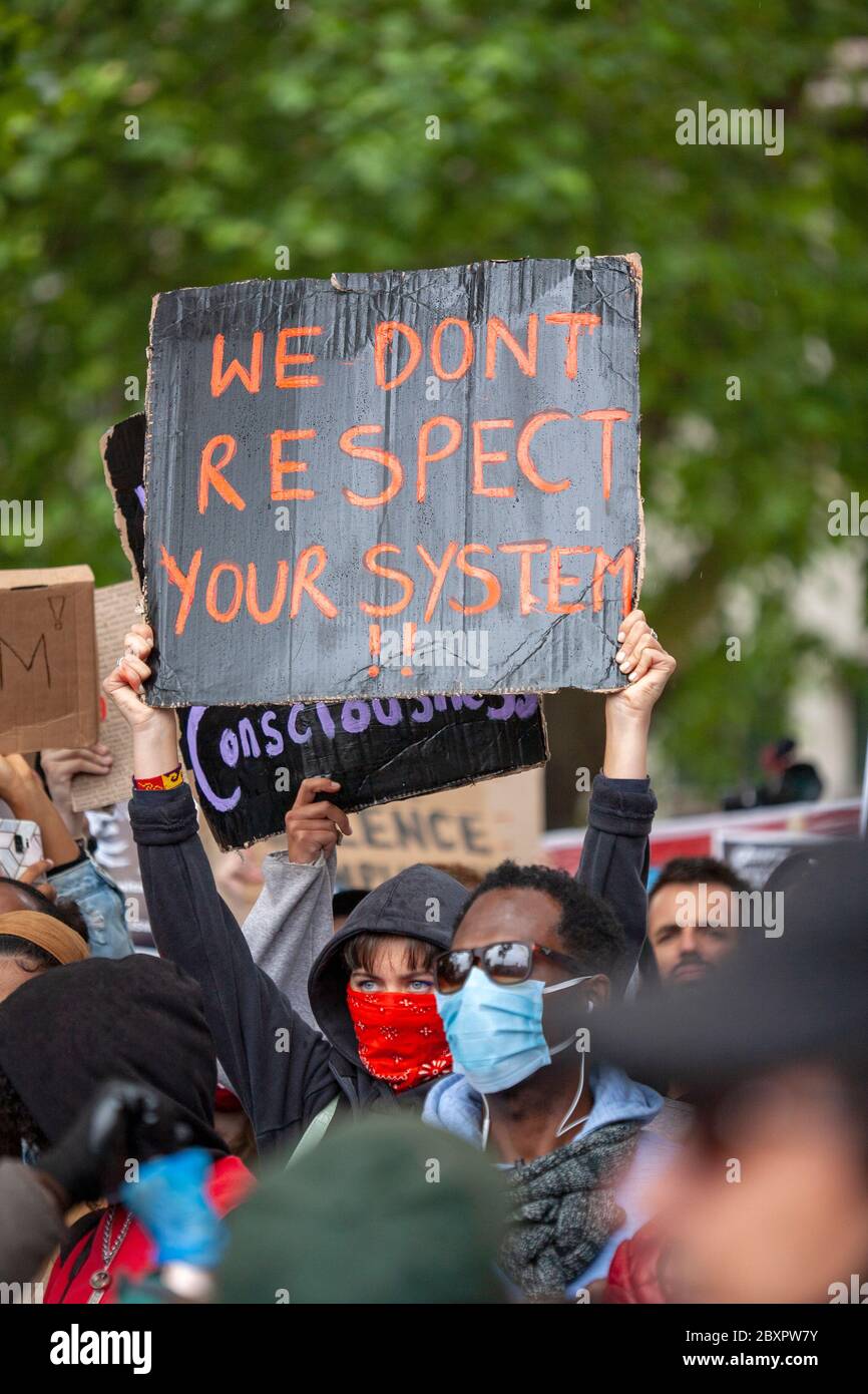 Mujer, con una sudadera con capucha y máscara, sosteniendo un cartel en la  protesta de Black Lives Matter UK, Parliament Square, Londres, Inglaterra,  Reino Unido Fotografía de stock - Alamy