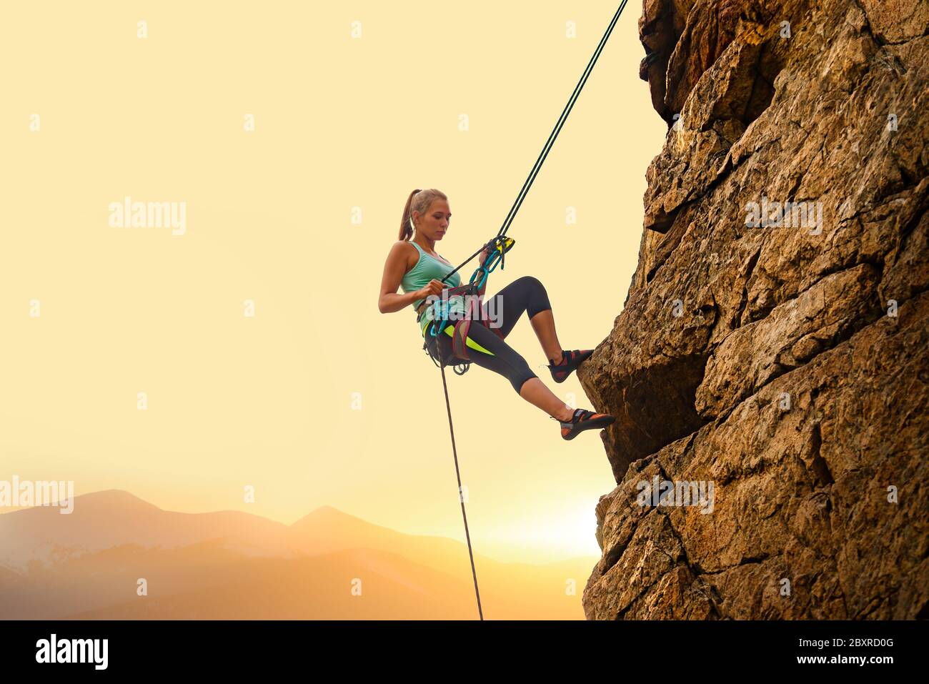 manipular Sinfonía Madurar Hermosa mujer escalando en la roca alta en Foggy Sunset en las montañas.  Aventura y concepto de Deporte extremo Fotografía de stock - Alamy