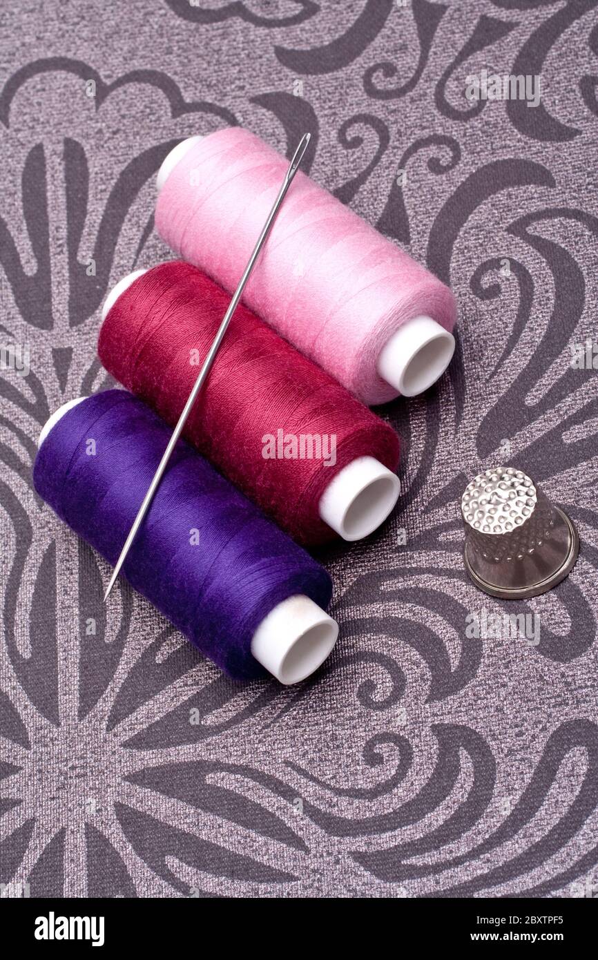 hilo de color para coser con aguja y dedal Foto de stock