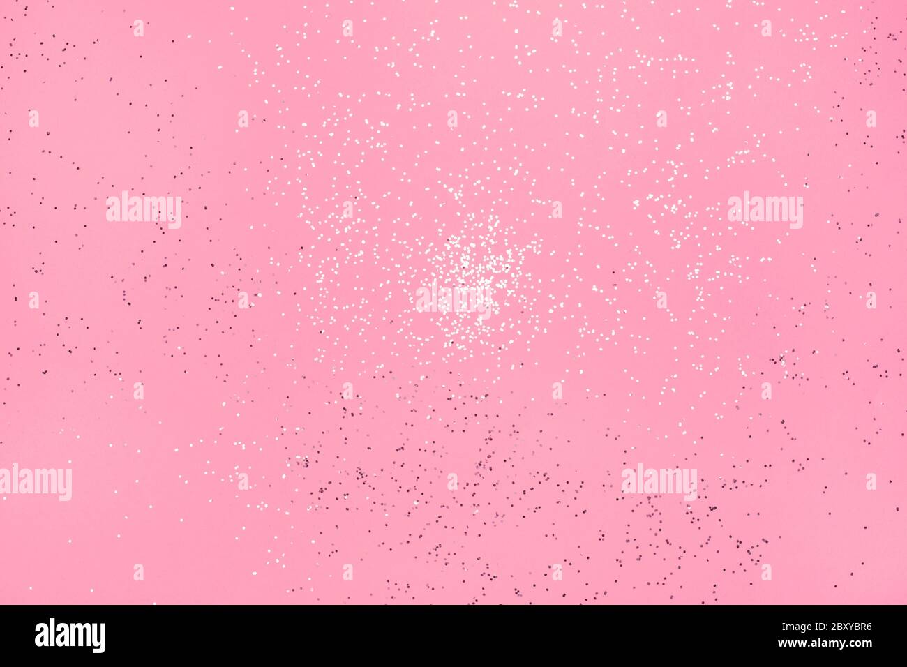 Brillo plateado en caída sobre fondo rosa pastel. Concepto festivo  Fotografía de stock - Alamy