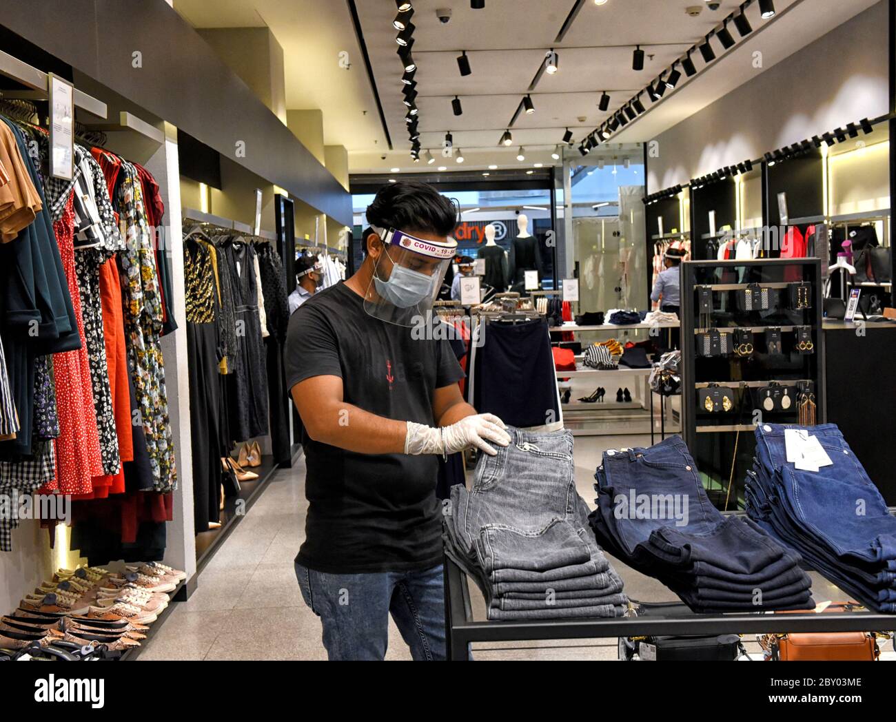 Un vendedor visto llevar máscara de escudo facial dentro de una tienda de  ropa de la ciudad del sur Mall Kolkata.el gobierno indio ha dado permiso  para reanudar el negocio a partir