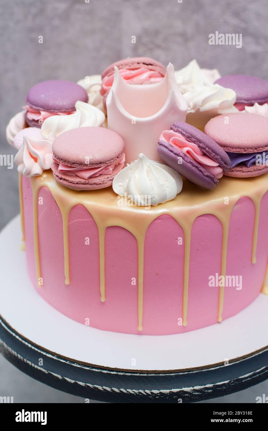 Pastel rosa de cumpleaños para una niña con corona de fondant, chocolate  blanco derretido, merengue y pastel de fondo gris Fotografía de stock -  Alamy