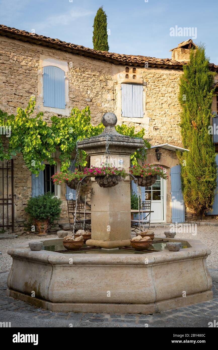 Cestas colgantes en una fuente en el patio de una casa típica en Provenza,  Francia Fotografía de stock - Alamy