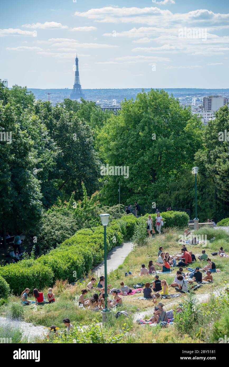 La gente en el parc de Belleville disfrutando de la vista en la torre Eiffel durante el día soleado después de que el cierre de la cárcel Covid-19 ha terminado Foto de stock
