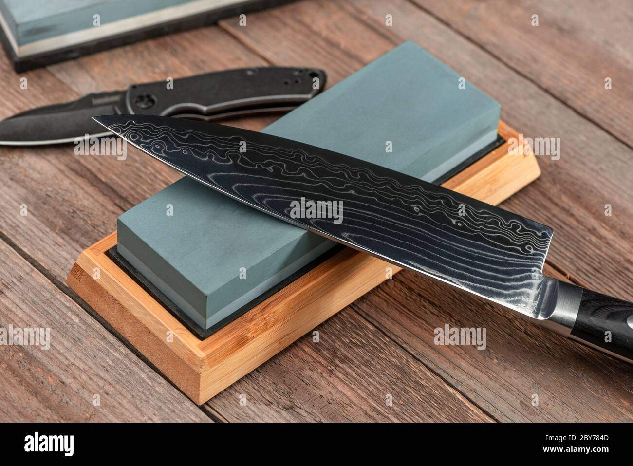 Afilar un cuchillo japonés Gyuto y un cuchillo de gato con una piedra de  tiro Fotografía de stock - Alamy