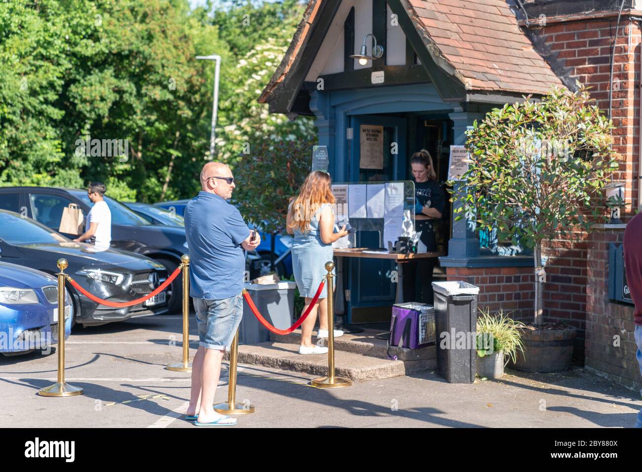 Pub británico tradicional en un día de verano superando las restricciones pandémicas del Coronavirus COVID-19 ofreciendo servicio de comida para llevar para cerveza y. Foto de stock