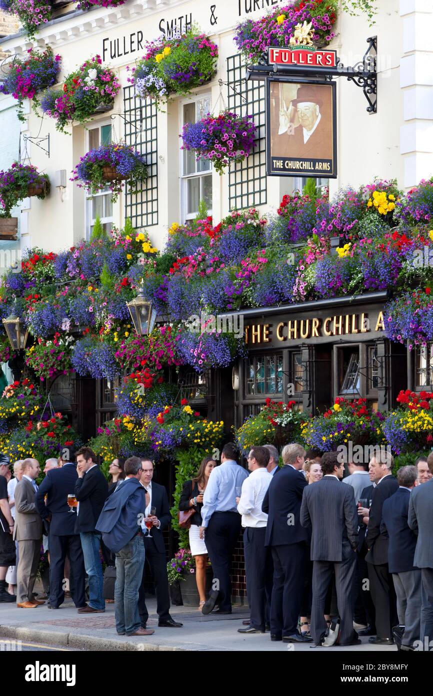 Después de trabajar bebedores fuera de flor se decantó el pub "The Churchill Arms" en Kensington Church Street, Londres, Inglaterra, Reino Unido Foto de stock