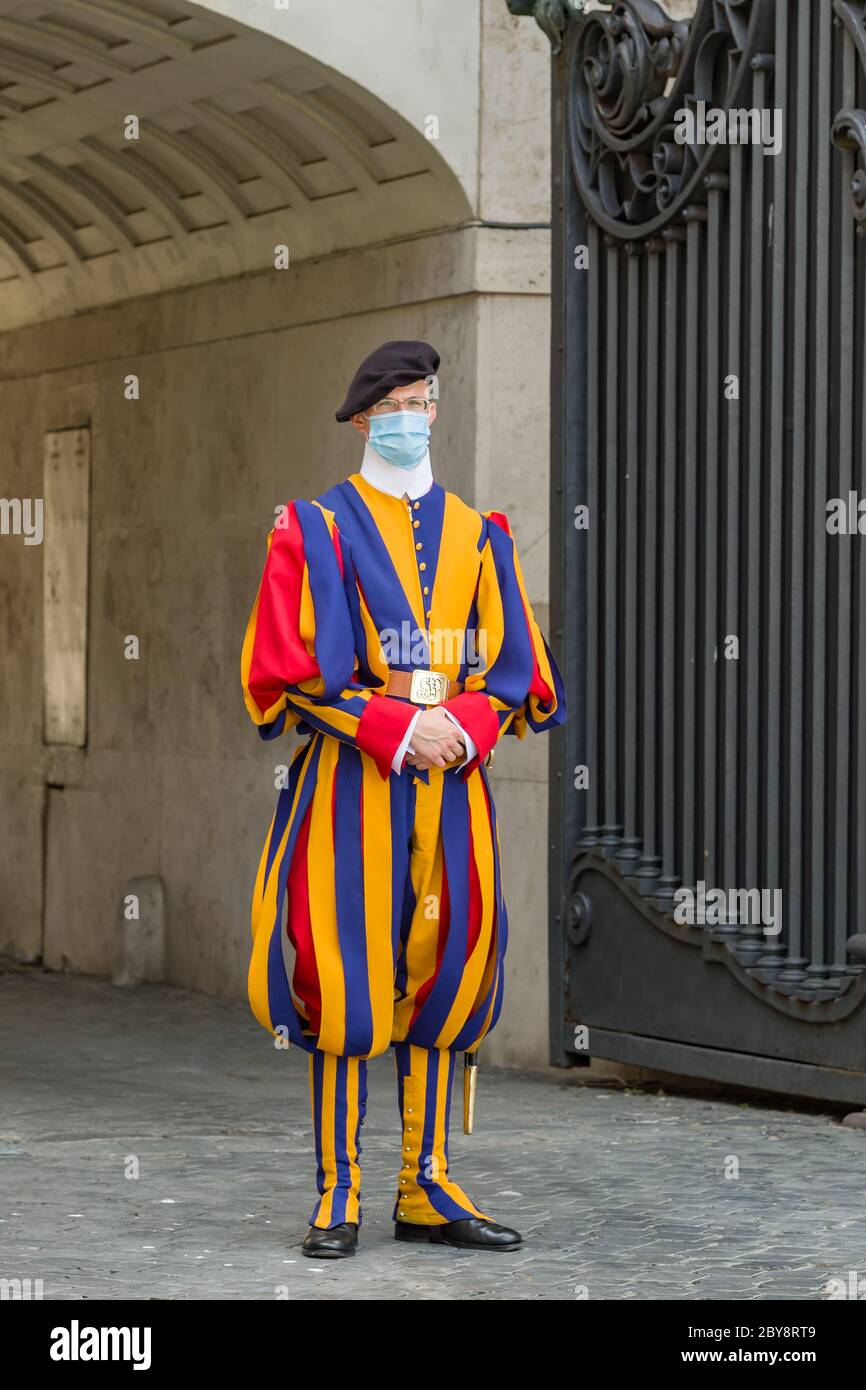 Guardia Suiza papal en uniforme con máscara médica protectora en St. La plaza de Pedro en el Vaticano durante la pandemia de Covid 19 Foto de stock