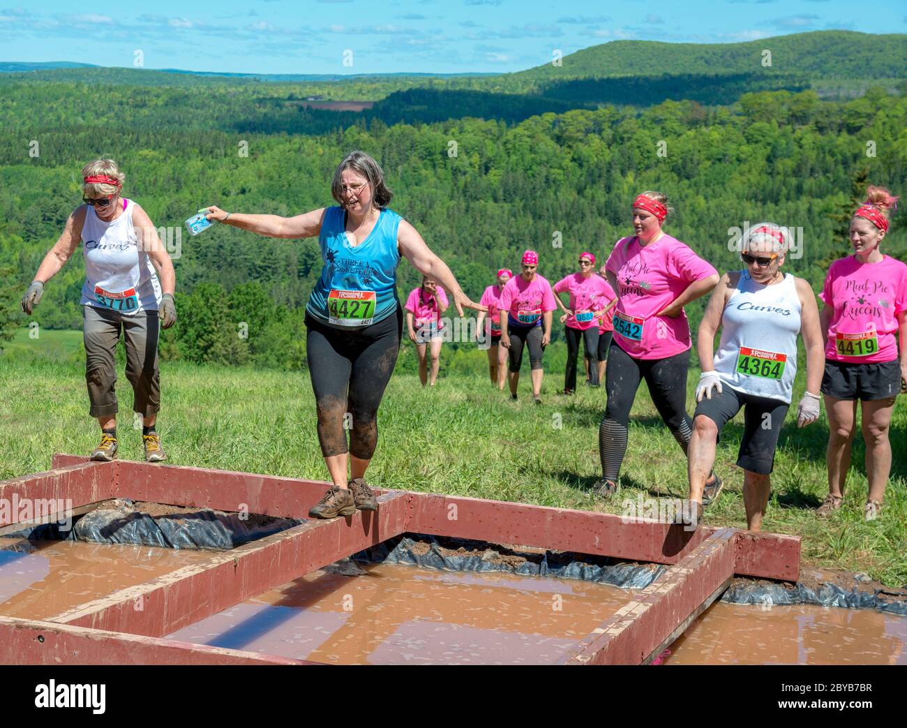 Poley Mountain, New Brunswick, Canadá - 10 de junio de 2017: Participando en la recaudación de fondos anual 'Mud Run for Heart'. Caminar por un rayo sobre el fangoso wa Foto de stock