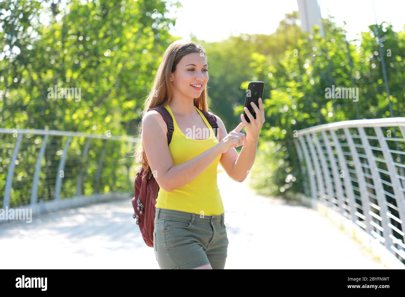 Joven mochilero niña comprobando las coordenadas GPS con su teléfono móvil en el parque natural. Concepto de turismo ecológico. Foto de stock