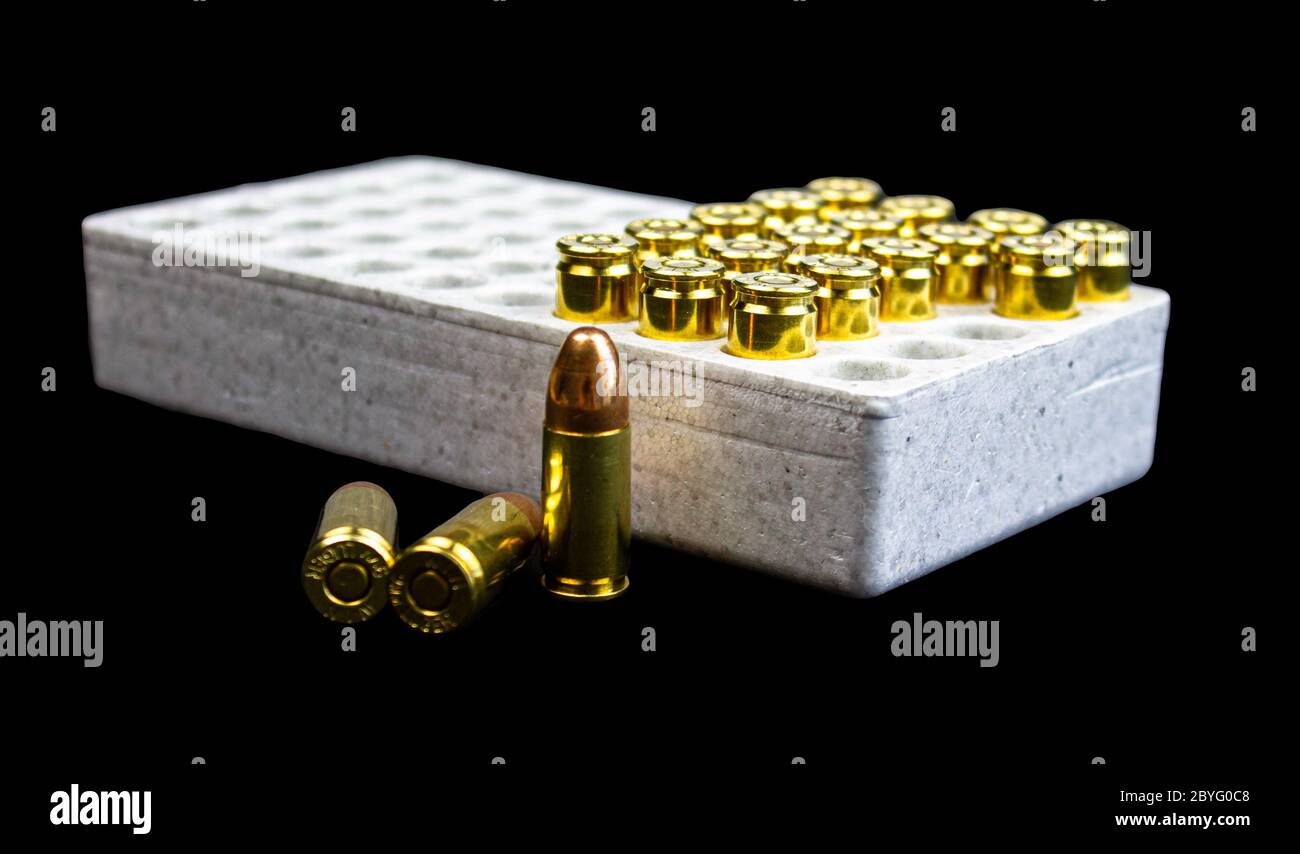 Unas balas de 9 mm aisladas en una caja blanca. Foto de stock
