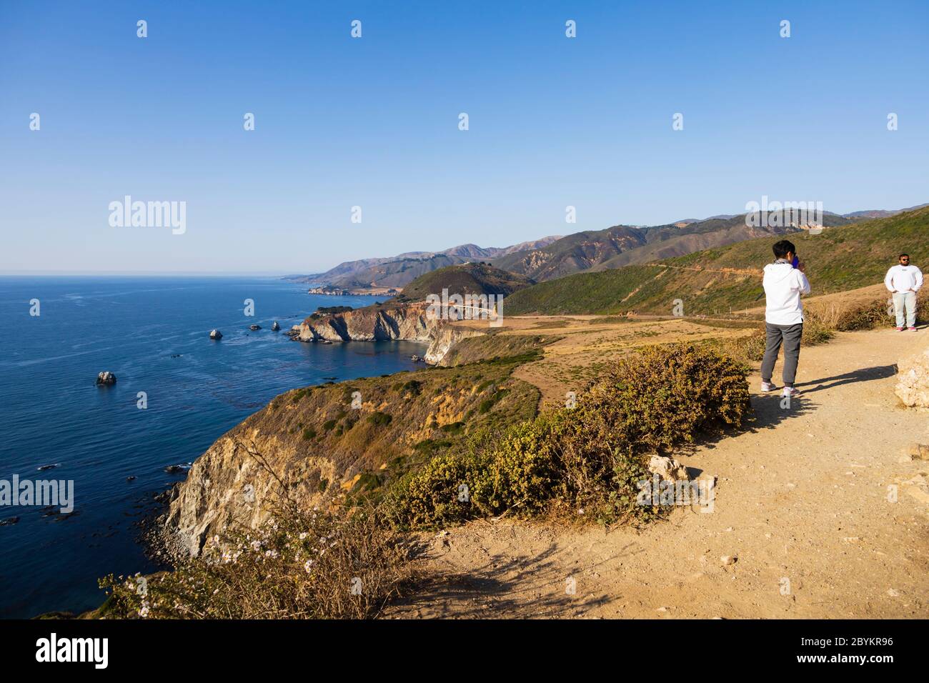 Los turistas posan para fotos, Océano Pacífico en la escarpada California cerca del puente Bixby Creek. Autopista CA1, la autopista de la costa del Pacífico. Estados Unidos de Ame Foto de stock