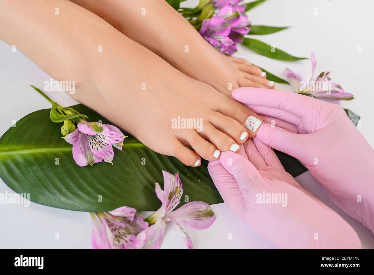 Hermosa mujer piel piernas pies vista superior con flores 