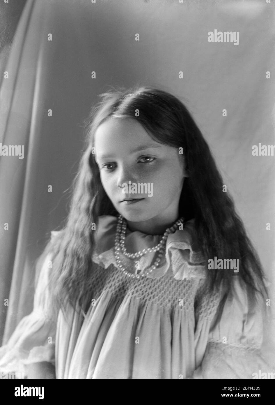 Una fotografía inglesa clásica de estilo victoriano tardío o Edwardiano temprano de una niña, mostrando la moda y el estilo de la época. Foto de stock
