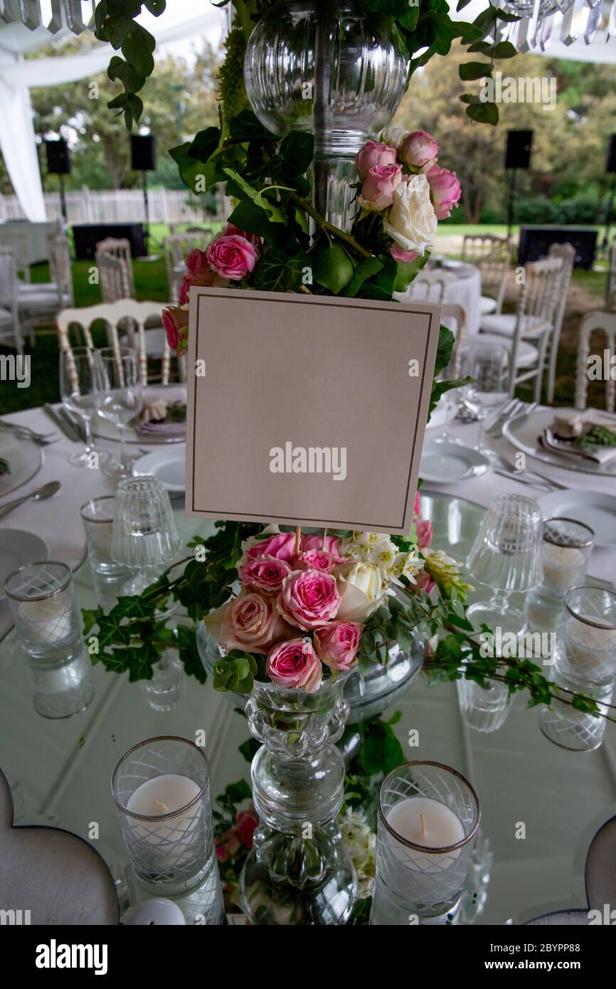 Número de mesa puesto de una recepción de boda al aire libre de lujo en el campo; sillas tiffany rústicas blancas, arreglos florales de mesa, centavo de cristal Foto de stock