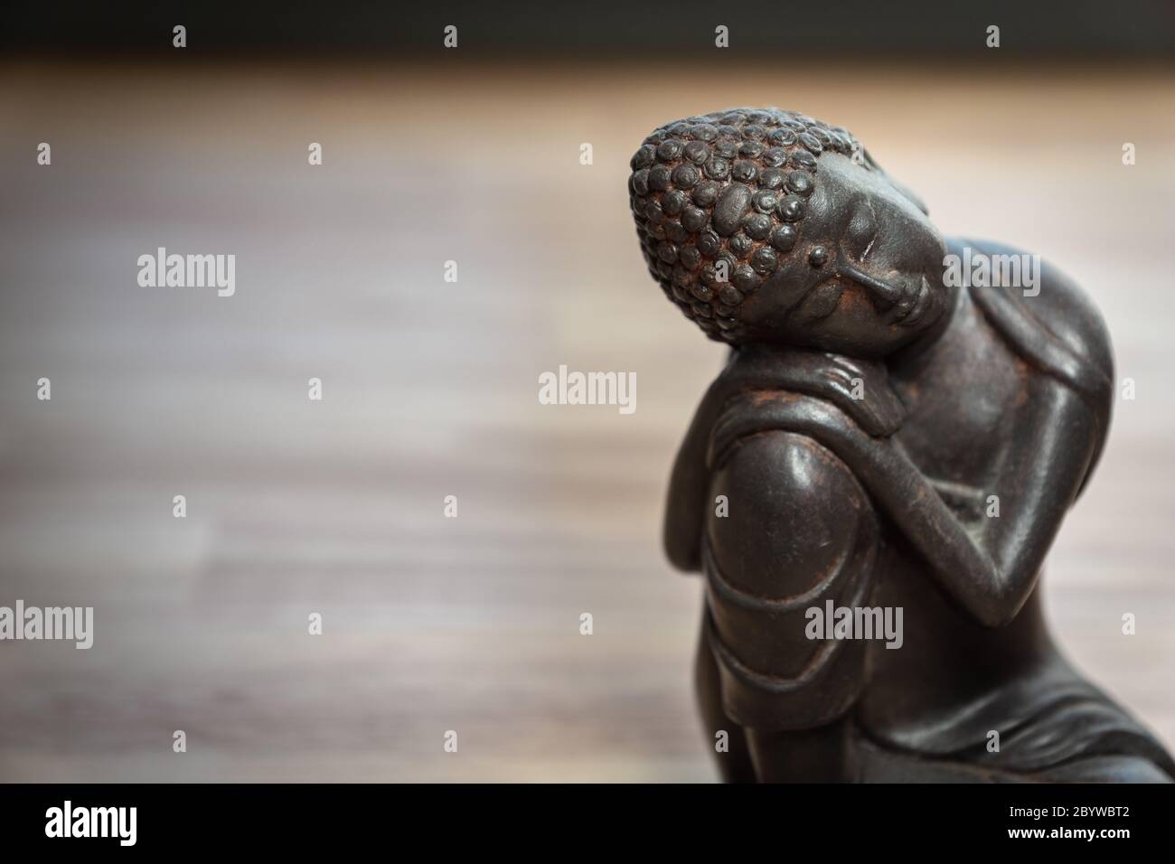 Escultura Buddah sobre escritorio - miniatura estatua buddah sobre escritorio - concepto de imagen para la mediación, atención, relajación, filosofía Foto de stock