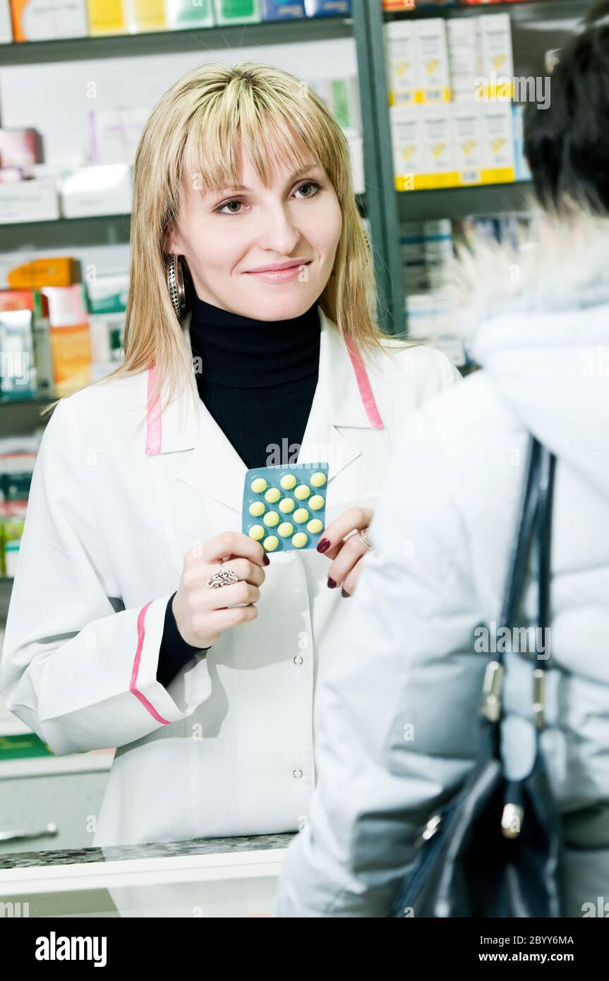 alegre farmacéutico y cliente en farmacia Foto de stock