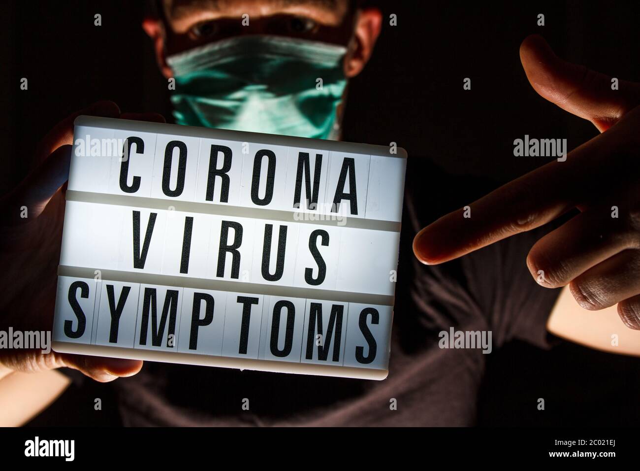 Hombre con máscara protectora tarjeta de retención con texto sobre la enfermedad del Coronavirus. ¿Qué es el Coronavirus? 2019 - nCoV, brote del virus Covid-19. Foto de stock