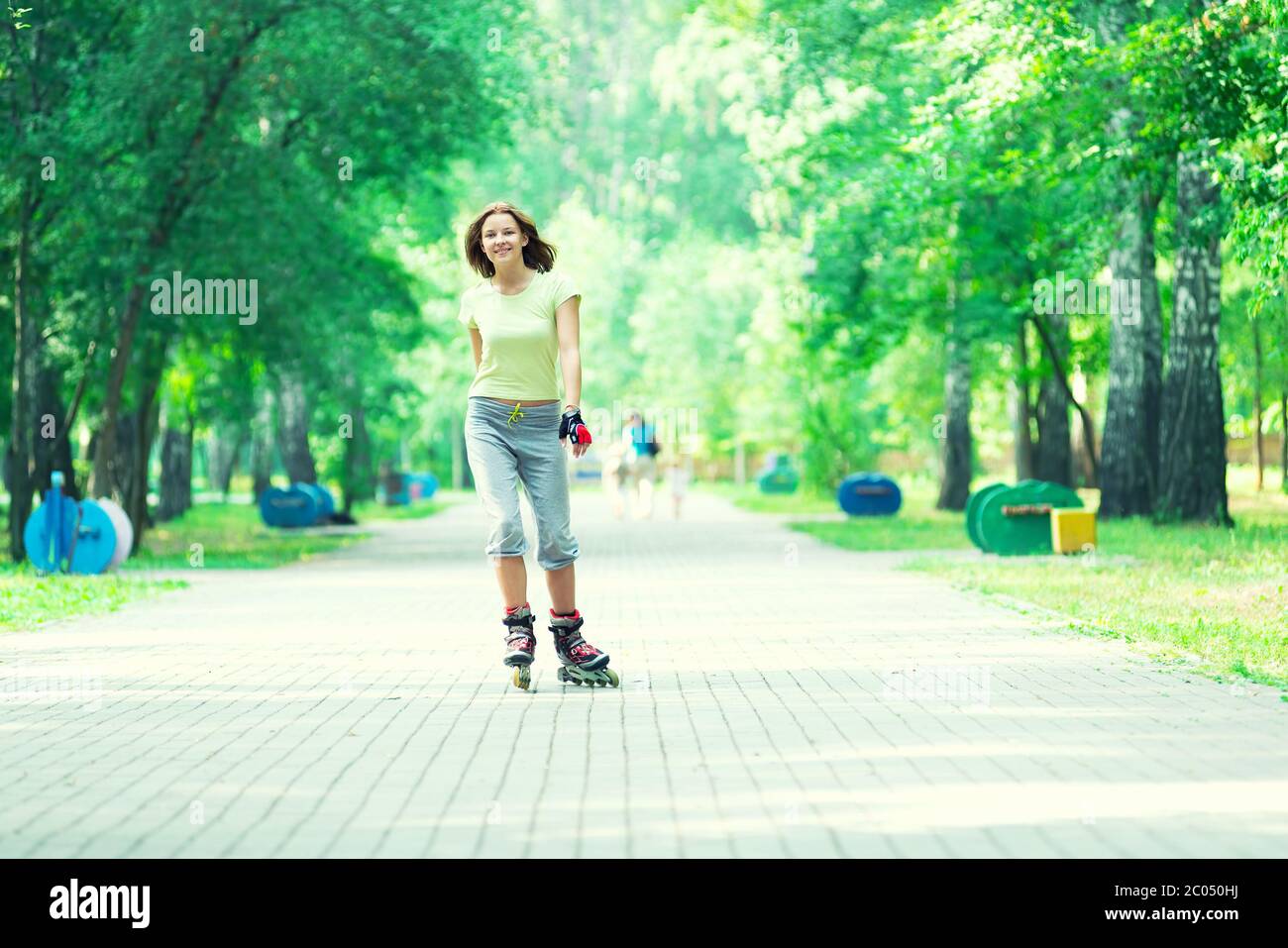 Patinar en el parque deportivo de chica patinar sobre patines en línea Foto de stock