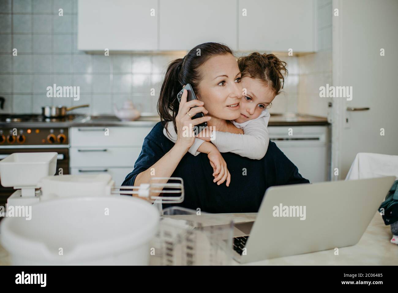 Madre trabaja en una oficina en casa, con el niño y el hogar, Austria Foto de stock