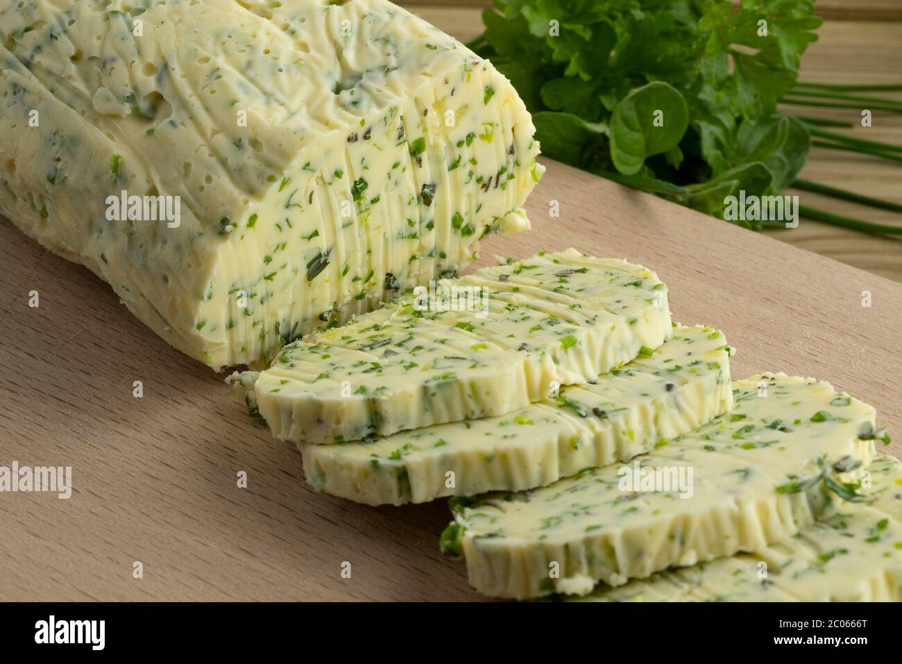 Tabla de cortar con mantequilla de hierbas recién hecha de cerca Foto de stock