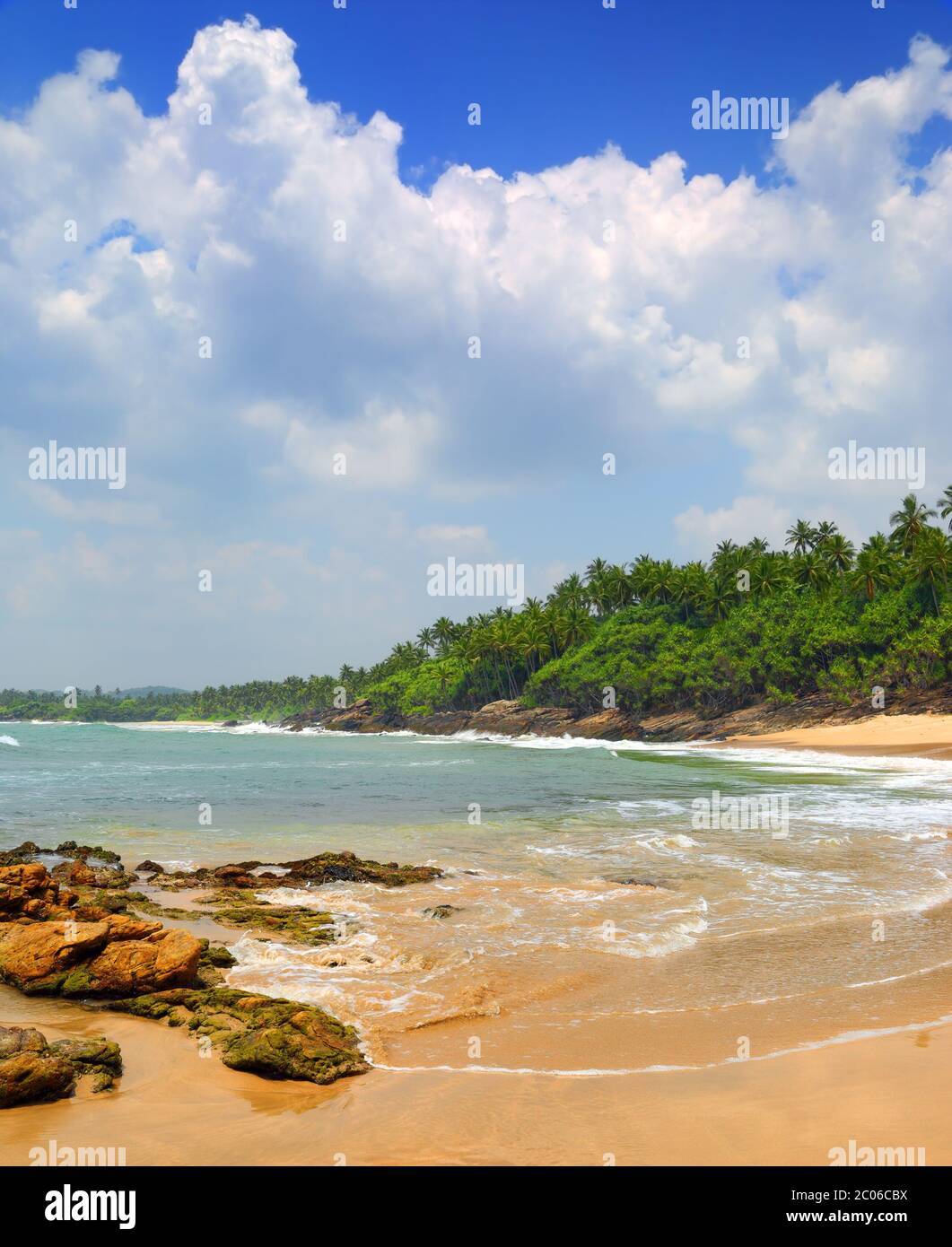 Las olas del mar sobre la playa tropical con piedras y rocas Foto de stock