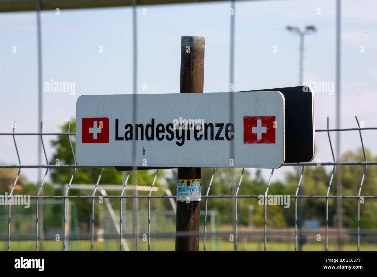 Wegen der Ausbreitung des Corona-virus haben die Schweiz und Deutschland ihre Grenzen geschlossen. Nun findet die Konversation am Grenzzaun statt. Kon Foto de stock