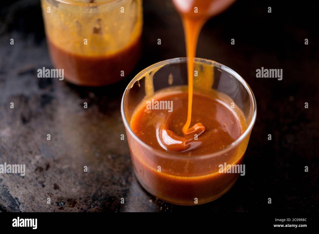 Esta dulce y deliciosa salsa de caramelo se puede utilizar como ingrediente para añadir sabor a las tartas, helados y muchos otros postres. Foto de stock