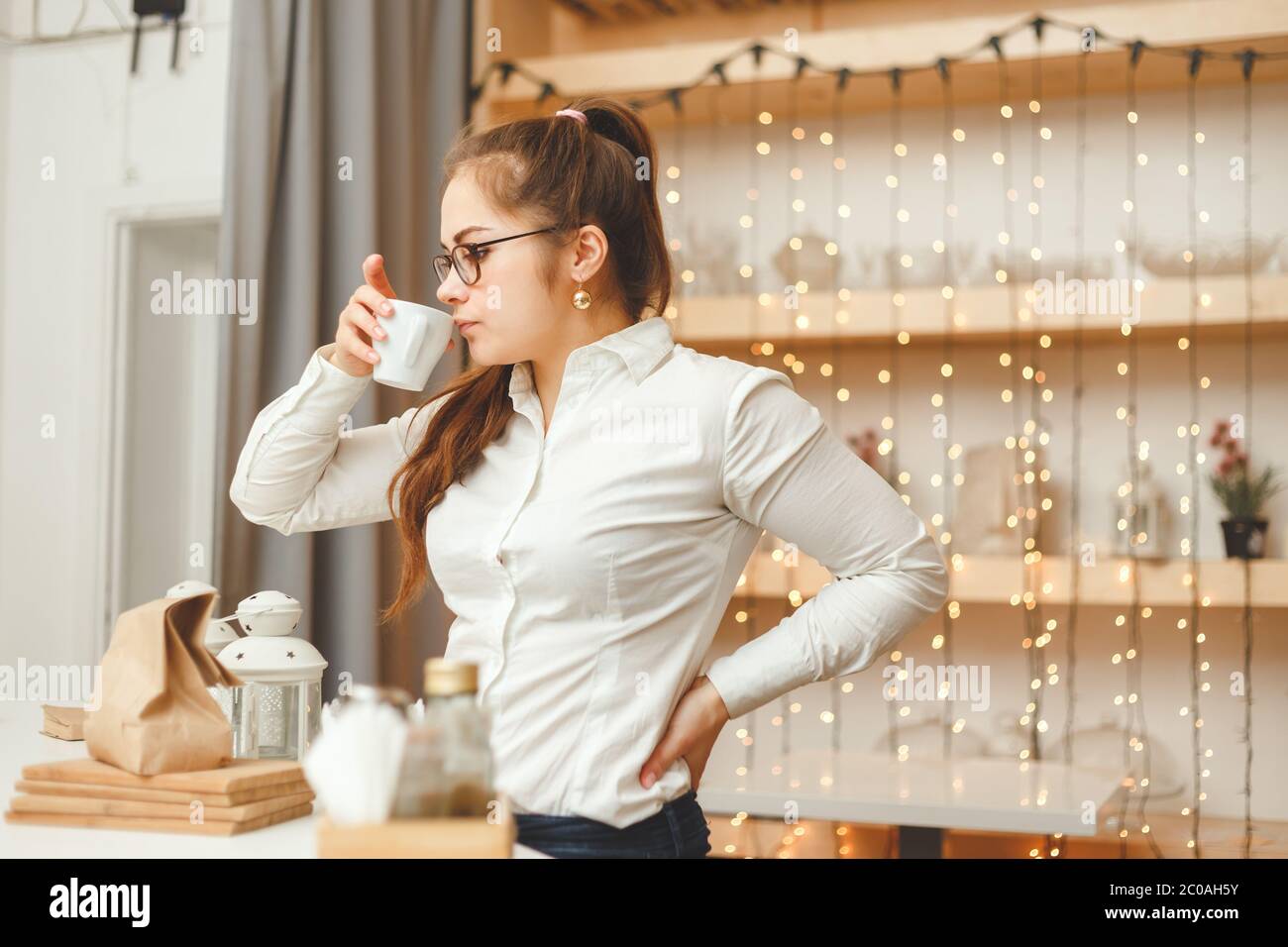 Joven empresaria caucásica bebiendo café y tiene un descanso. Vista lateral accidental Foto de stock