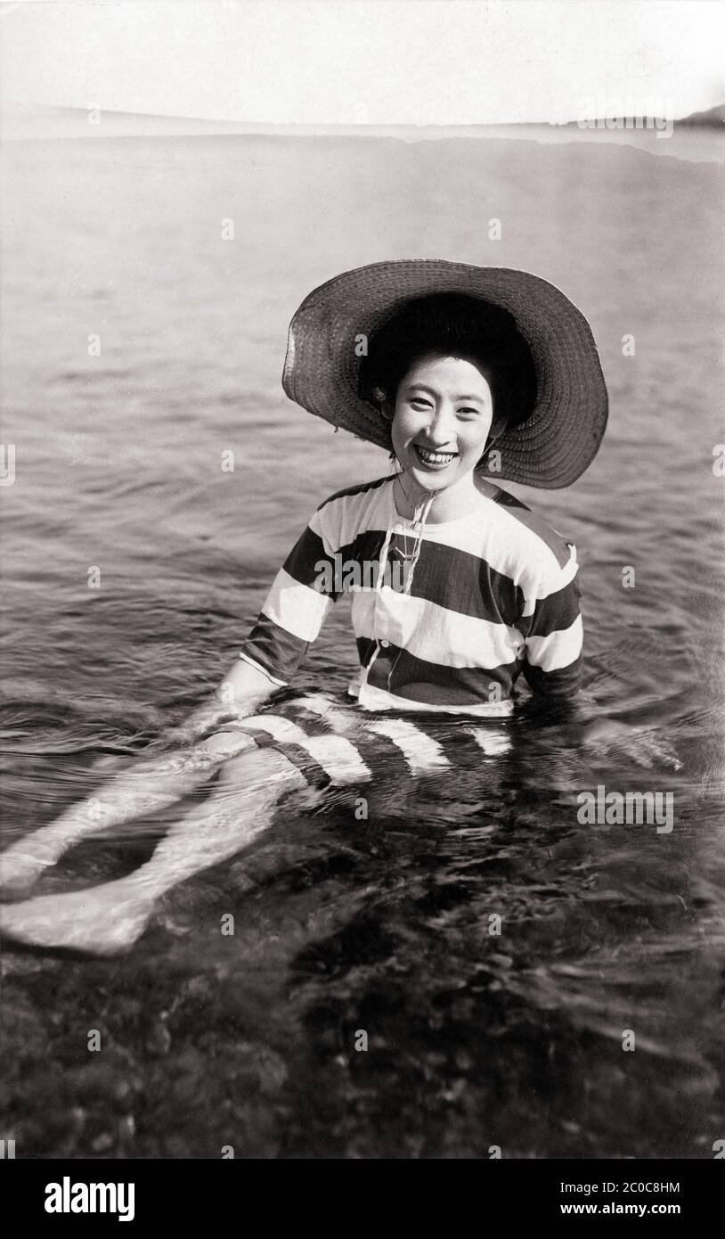1920 Japón - Mujer japonesa en traje de baño ] — Mujer con traje de baño de  rayas (シマウマ水着, Shimauma Mizugi, literalmente traje de baño cebra) y  sombrero de sol, sentada