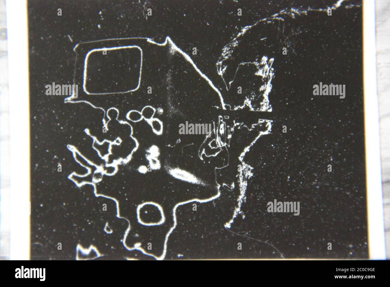 Fotografía extrema de los 70 años de la vendimia fina en blanco y negro de un ingeniero inteligente que mantiene una máquina de computadora. Foto de stock