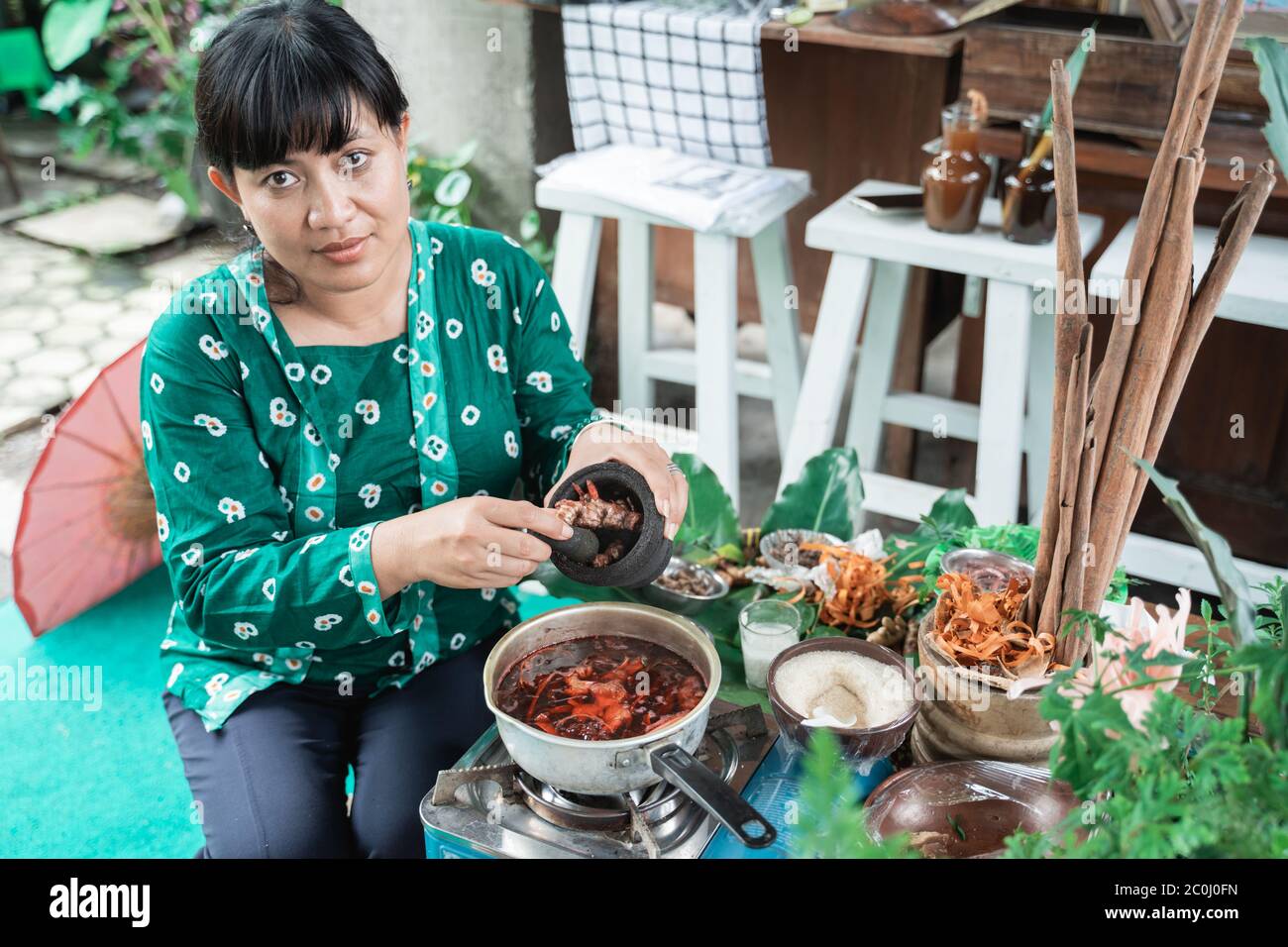 Las mujeres hacen medicamentos a base de hierbas hacen recetas tradicionales de hierbas javanesas hirviendo Foto de stock