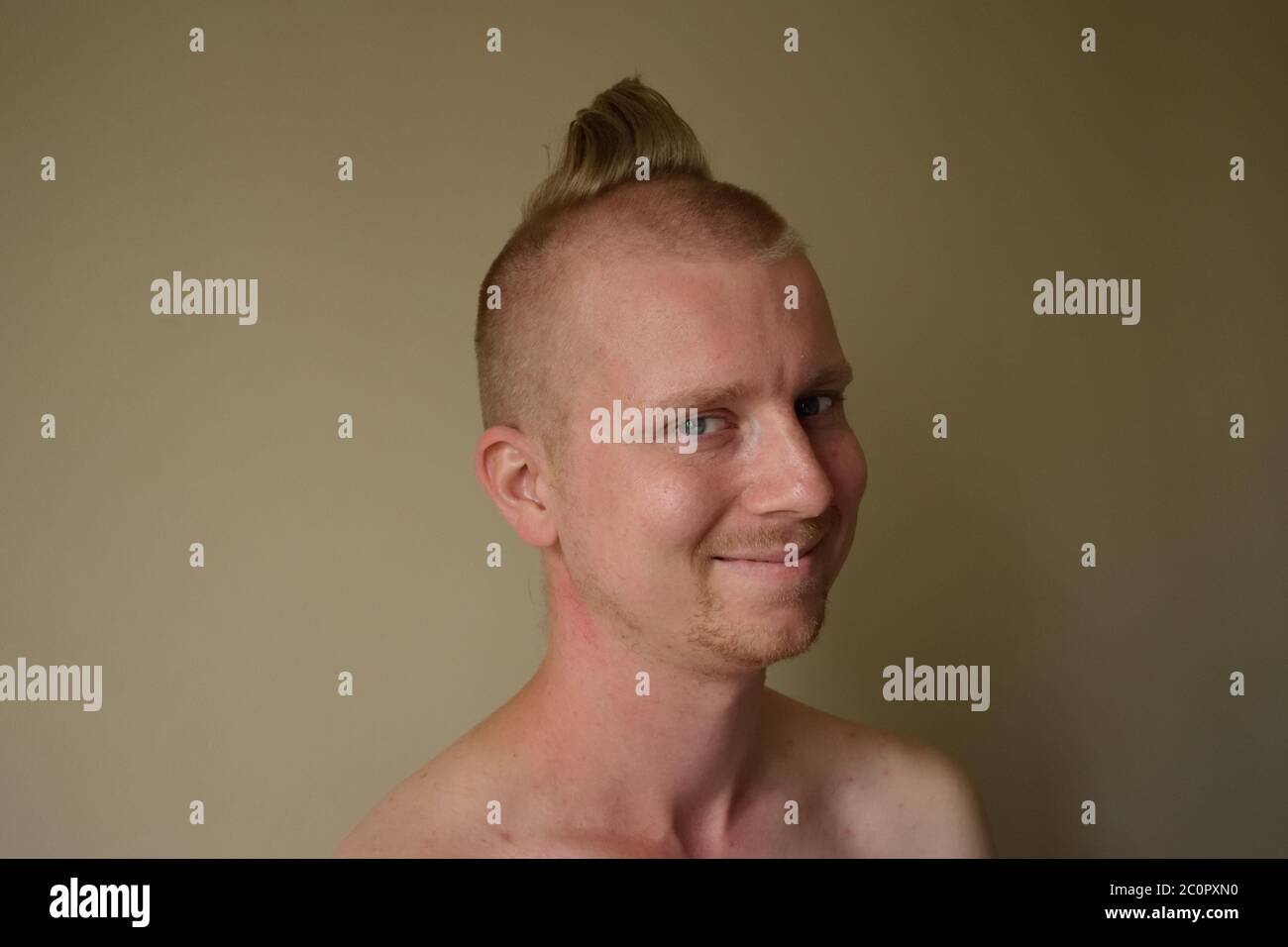 Joven con mal corte de pelo después de cortar su propio pelo en casa Foto de stock