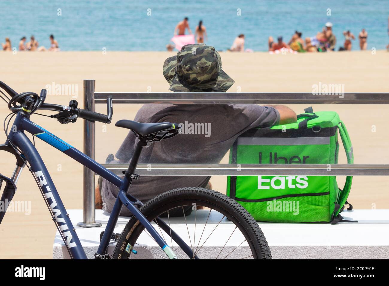 Las Palmas, Gran Canaria, Islas Canarias, España. Un mensajero de Uber Eats  se toma un descanso fuera de un restaurante frente a la playa Fotografía de  stock - Alamy