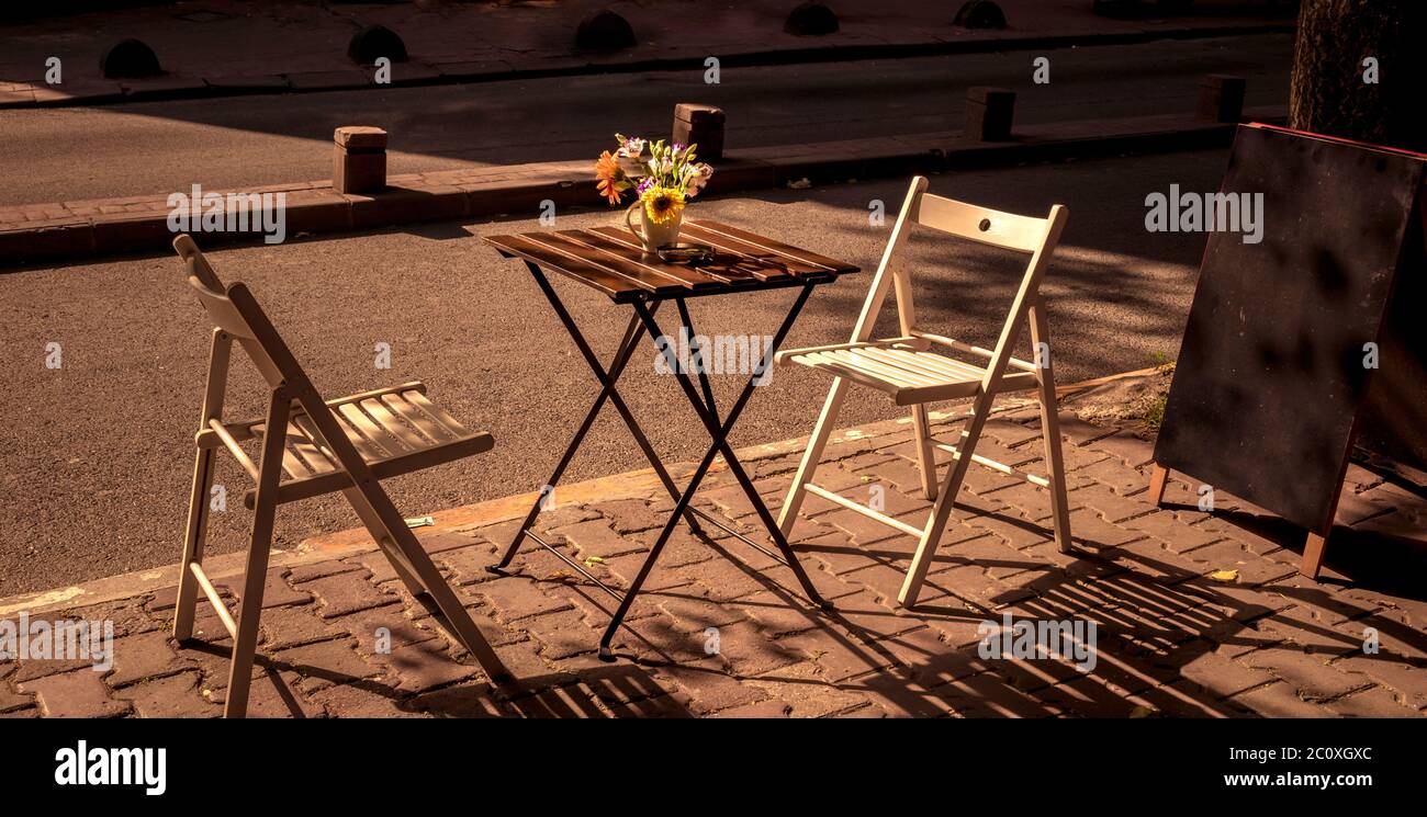 centro de mesa color café con girasol. Fondo difuminado y mantel blanco.  Decoración en mesa de restaurante. Florero de mesa. Stock Photo