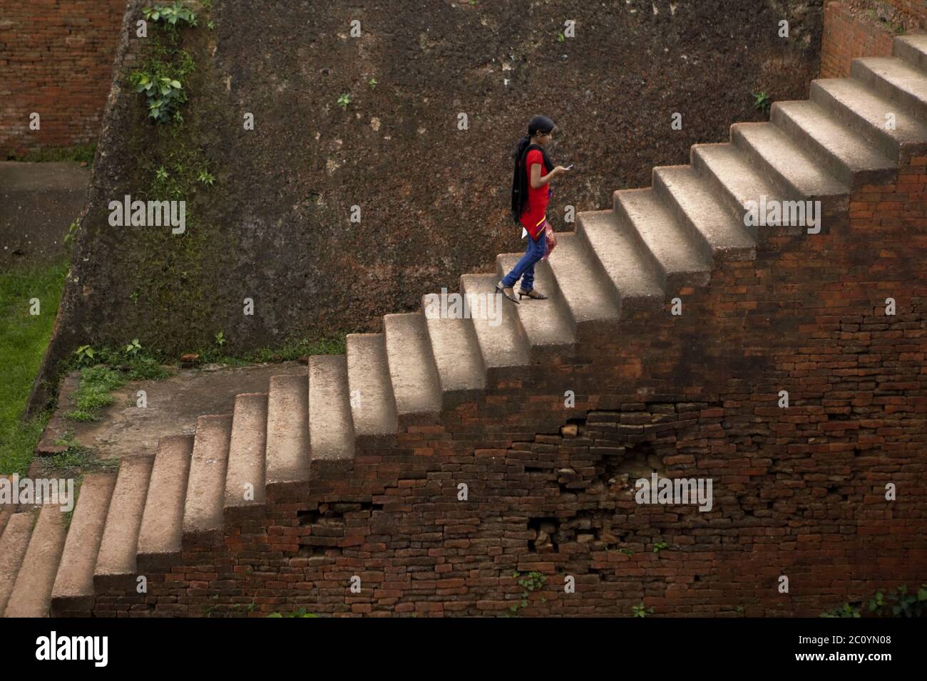 Una mujer que se acerca a la escalera del Monasterio 1 en el antiguo complejo universitario budista de Nalanda en Nalanda, Bihar, India. Foto de stock