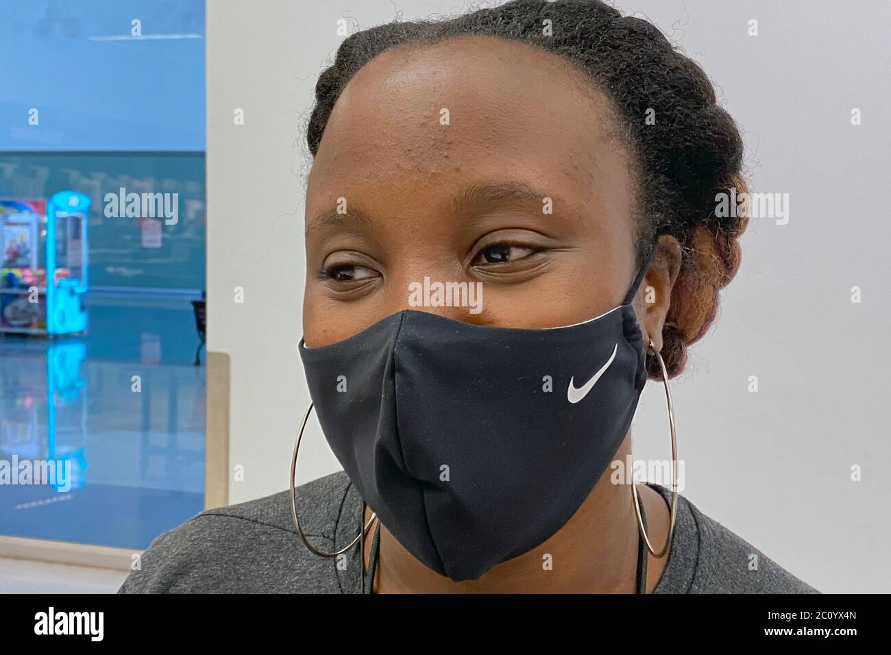 Una empleada lleva una máscara con el logo de swoosh en la tienda Nike  Factory Store en el centro comercial de tiendas directas de fábrica Prizm  Outlets en medio de la pandemia