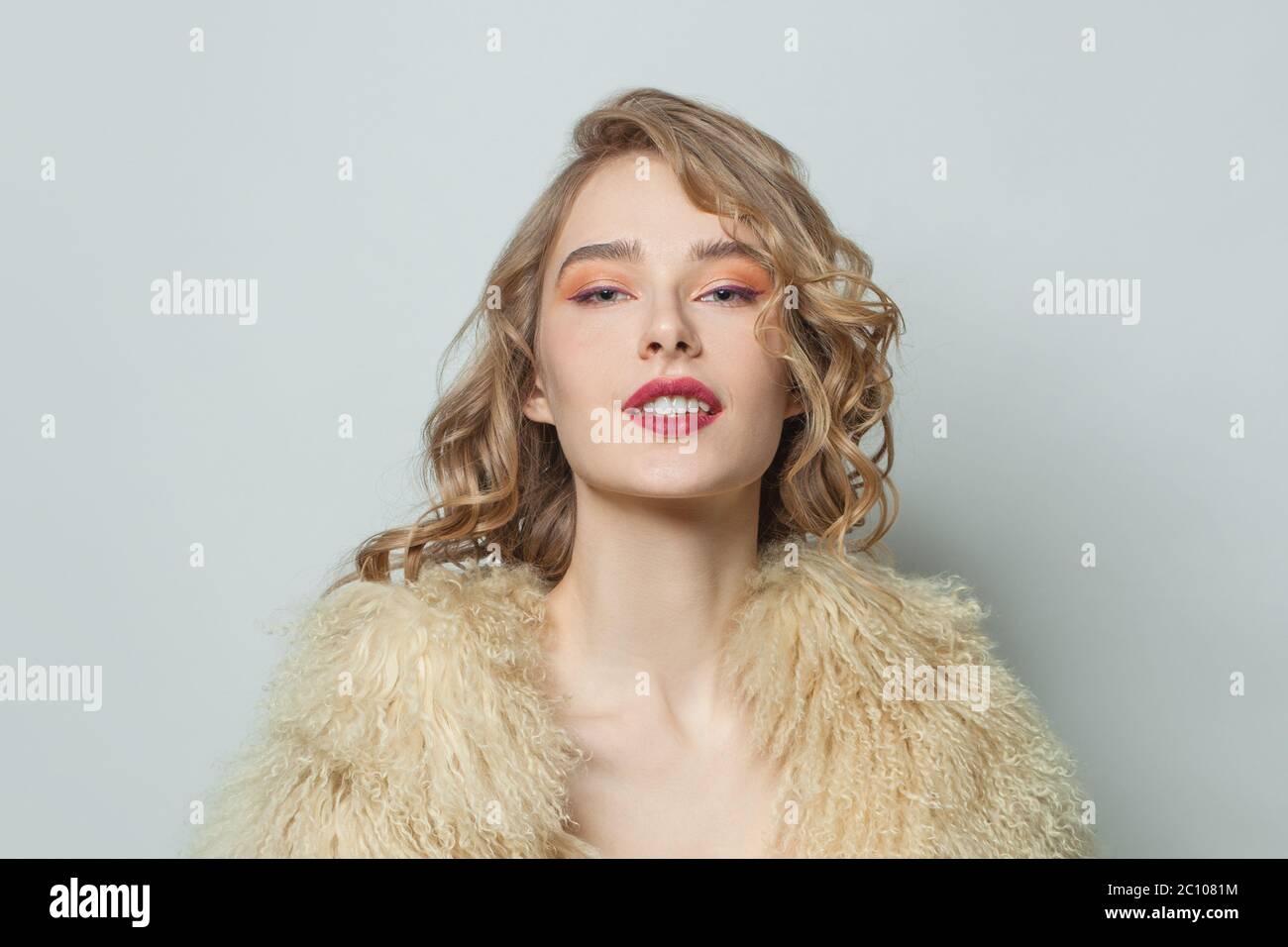 Retrato de mujer agradable en el abrigo de piel sintética ecológico sobre  fondo blanco Fotografía de stock - Alamy
