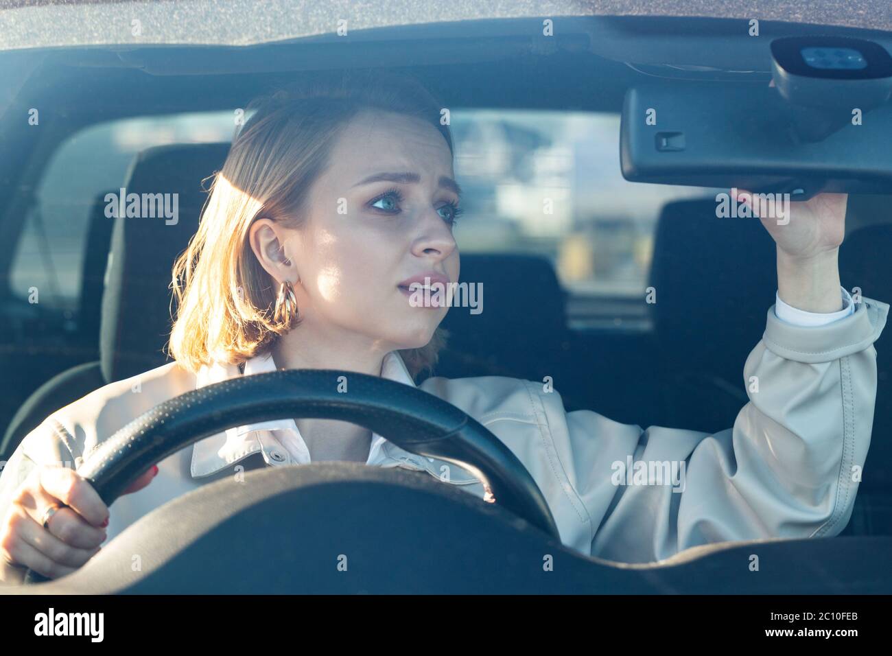 Mujer conductor coche por primera vez, trata de evitar un accidente de coche, está muy nervioso y asustado, se preocupa, se aferra firmemente a la rueda derecha, mirando en el Foto de stock