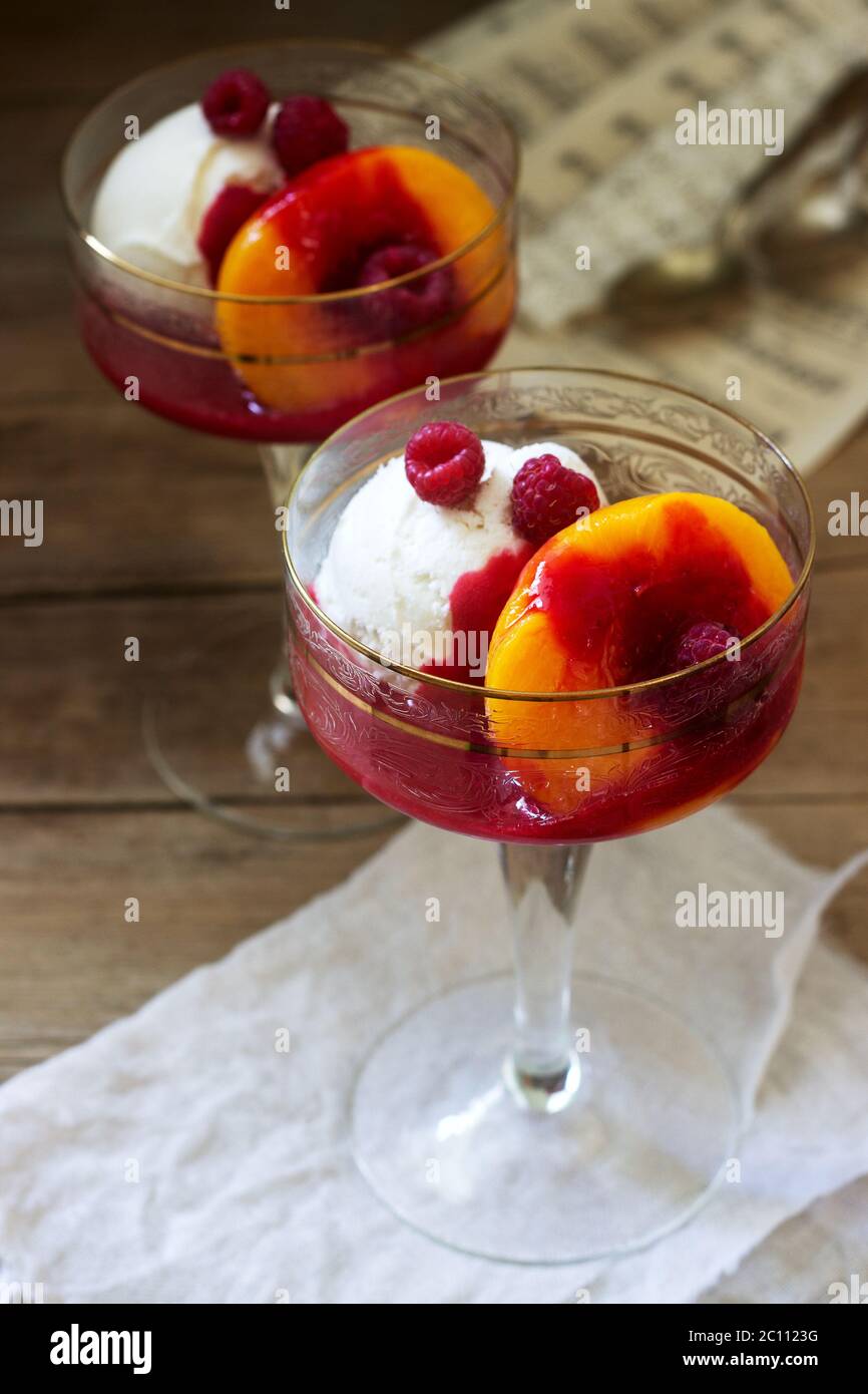 Helado, melocotón y salsa de frambuesa postre dedicado a la cantante de ópera australiana Melba. Estilo rústico. Foto de stock