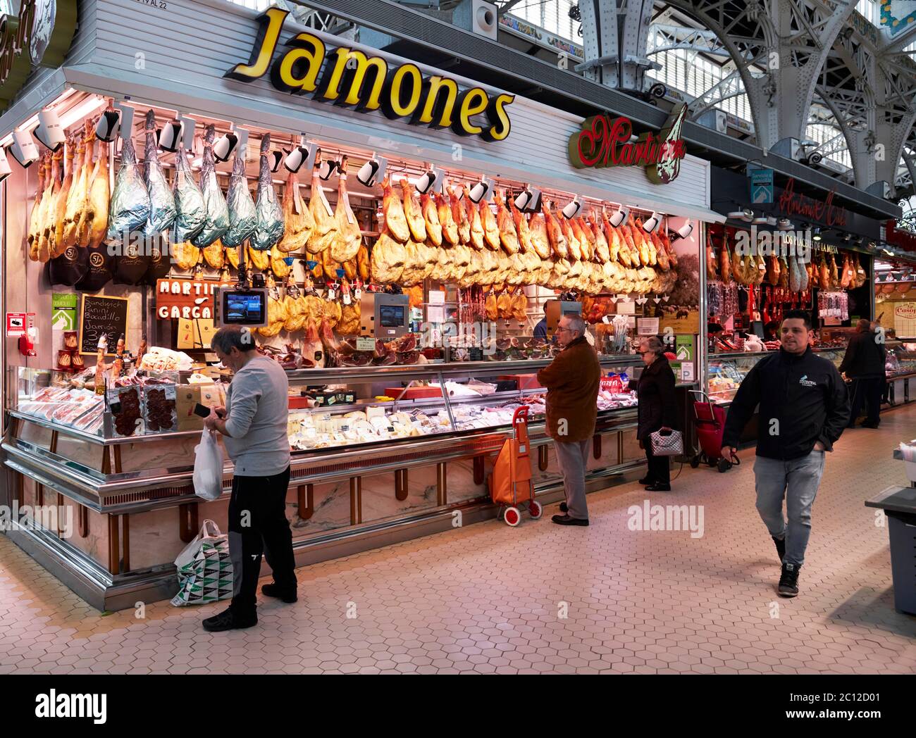 Puestos de venta de carne y quesos curados en el mercado Central de Valencia, España. Foto de stock