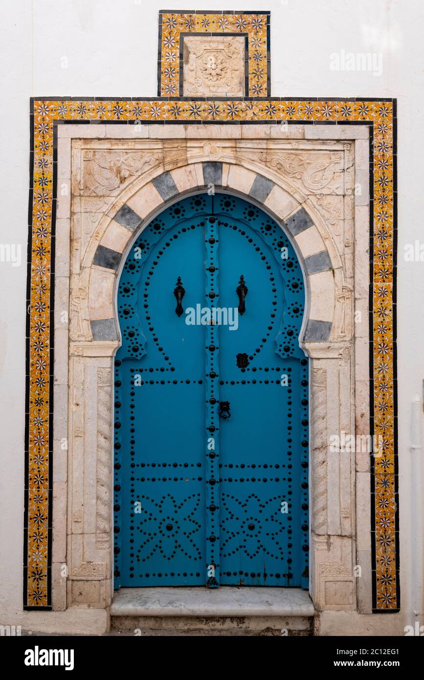 Puerta elaborada decorada de una casa tradicional en Sidi bou Said, Túnez, en estilo morisco con arcada y azulejos incrustados Foto de stock