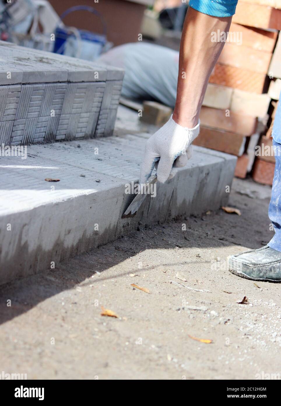 la tiladora procesa la superficie para colocar las baldosas de piedra en los escalones de la reparación del edificio de oficinas. Foto de stock
