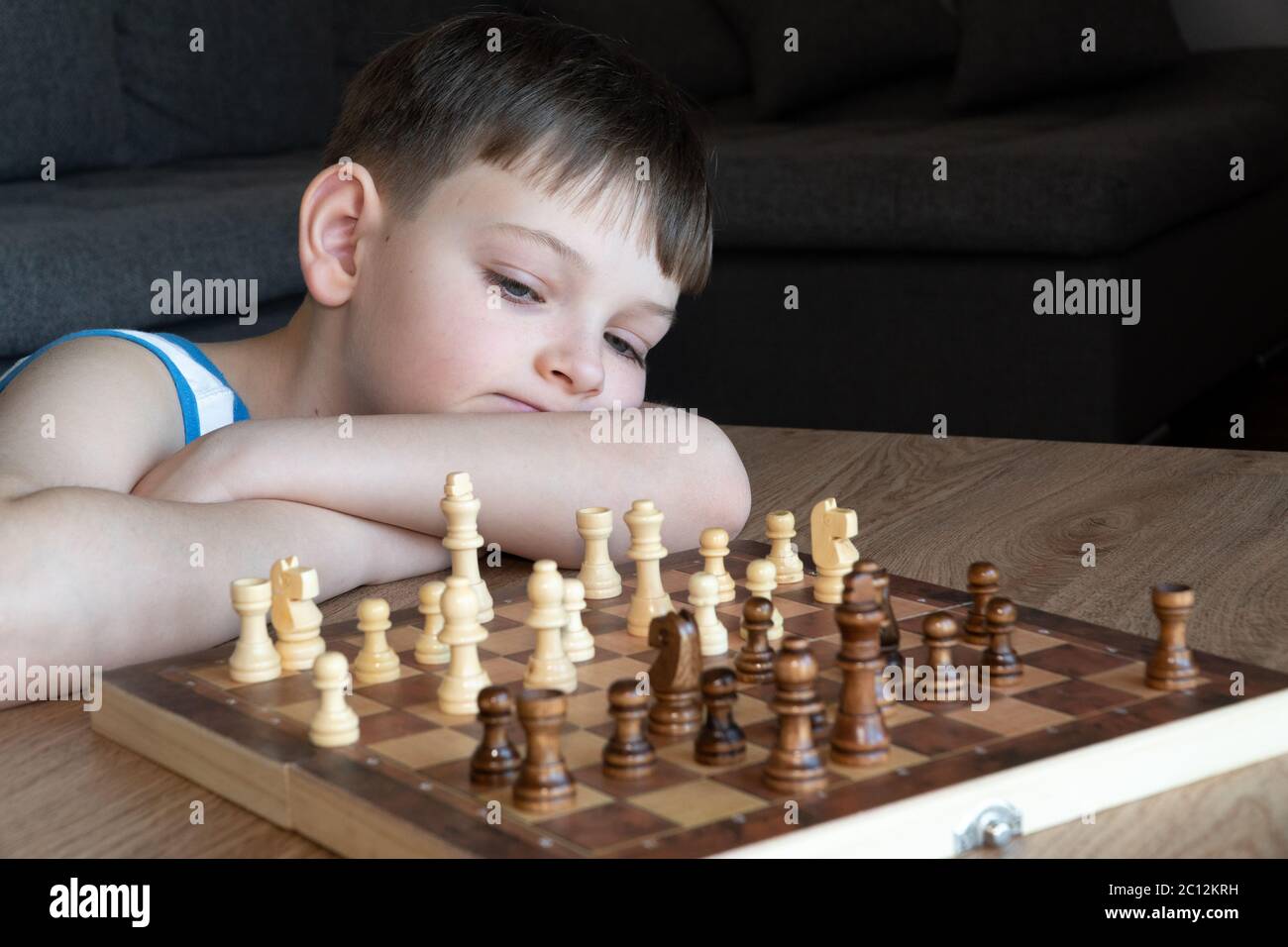 El niño serio perdido en el pensamiento jugando al ajedrez. Jugar juegos de  mesa, en cuarentena coronavirus. El niño jugando al ajedrez Fotografía de  stock - Alamy