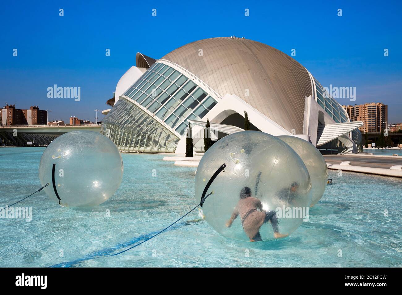 Turistas que se divierten en el interior de grandes esferas flotantes transparentes en el parque de la ciencia, Valencia, España. Foto de stock