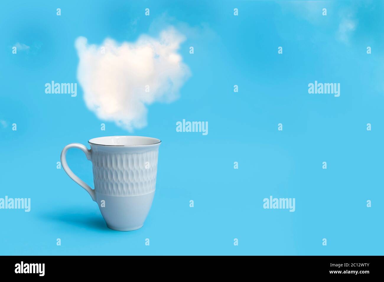Taza de café por la mañana en el hermoso cielo azul con nubes hinchadas de fondo y espacio para el texto Foto de stock