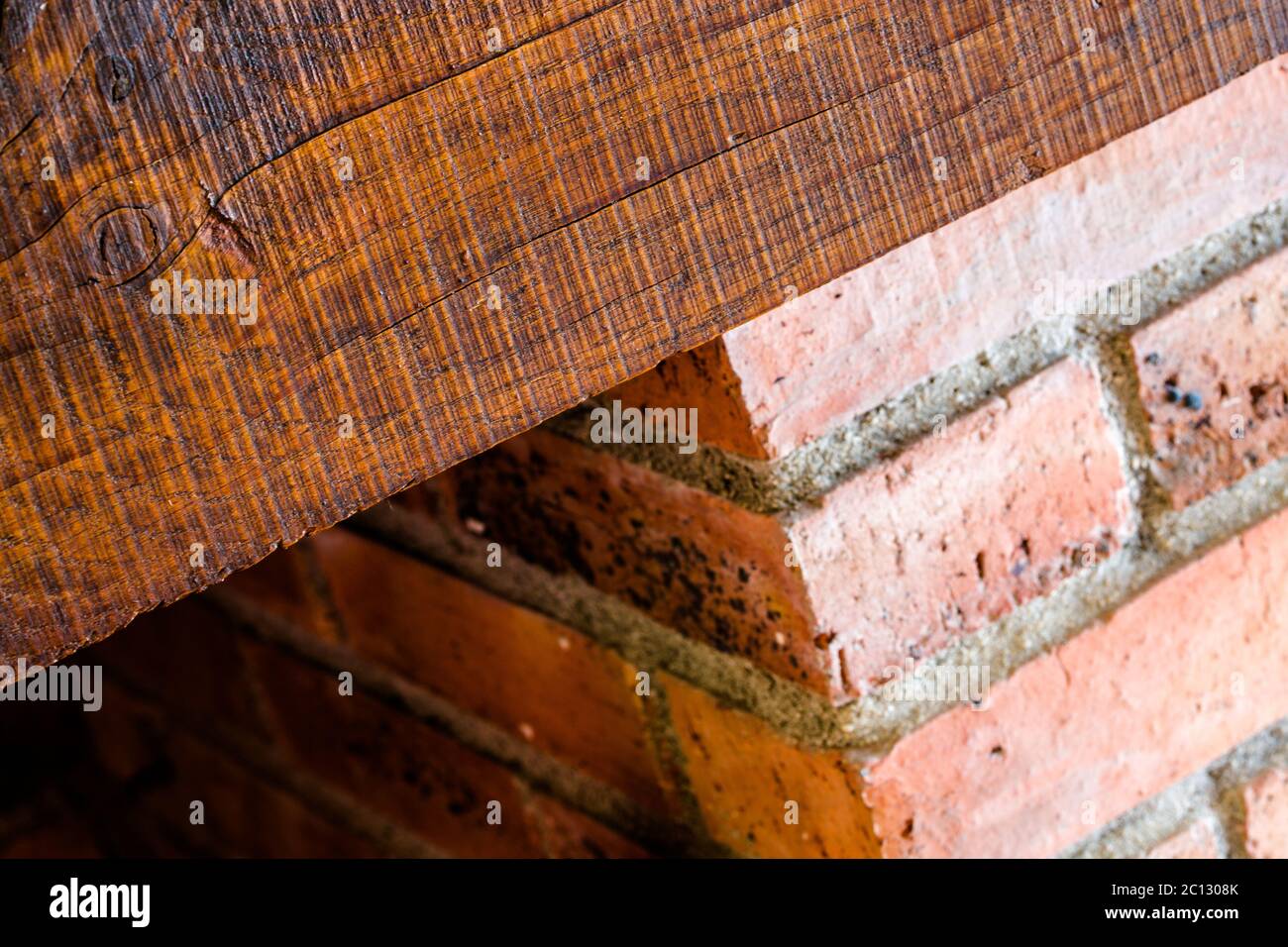 chimenea masiva con ladrillos expuestos y vigas de madera Foto de stock